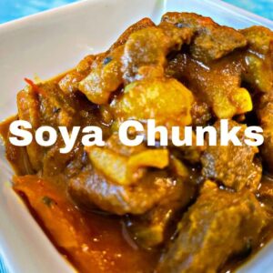 soya chunkcs with potato carrots and a stew gravy in a white bowl