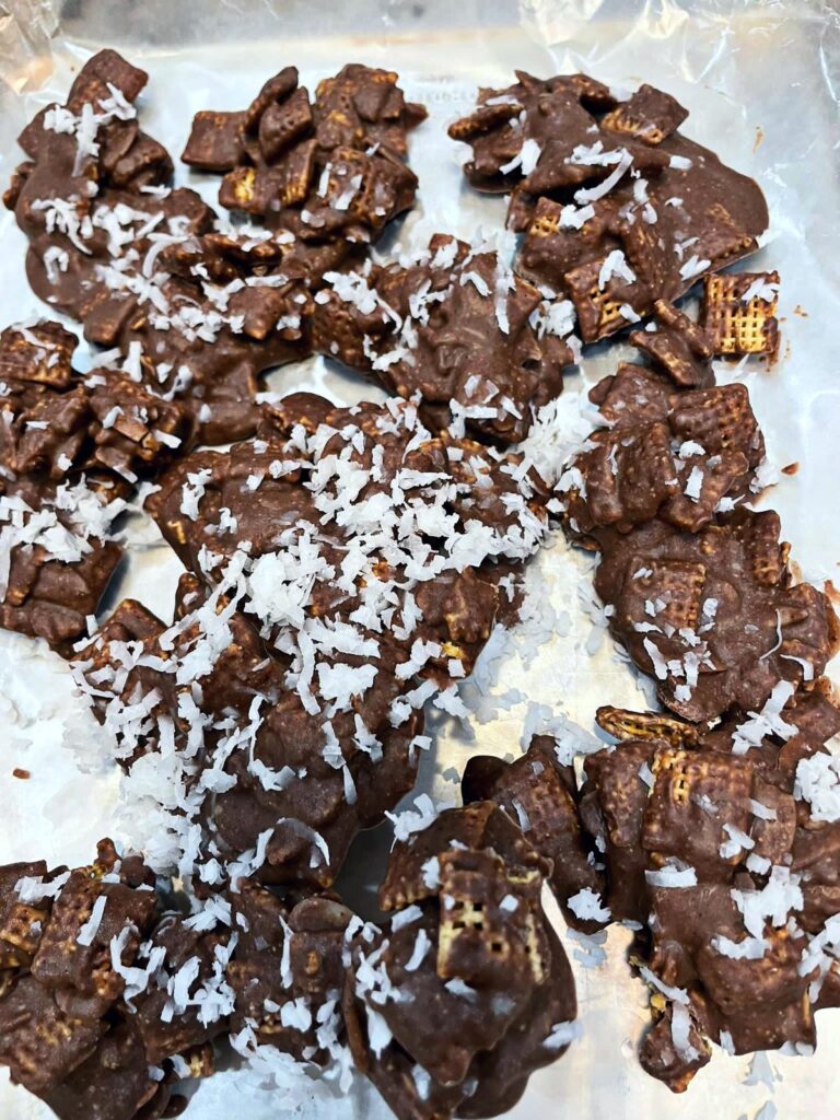 carob clusters topped with coconut shreds on wax paper