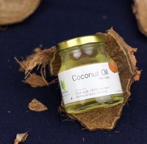 coconut oil in a labeled jar and sitting in the cracked shells of the coconut 