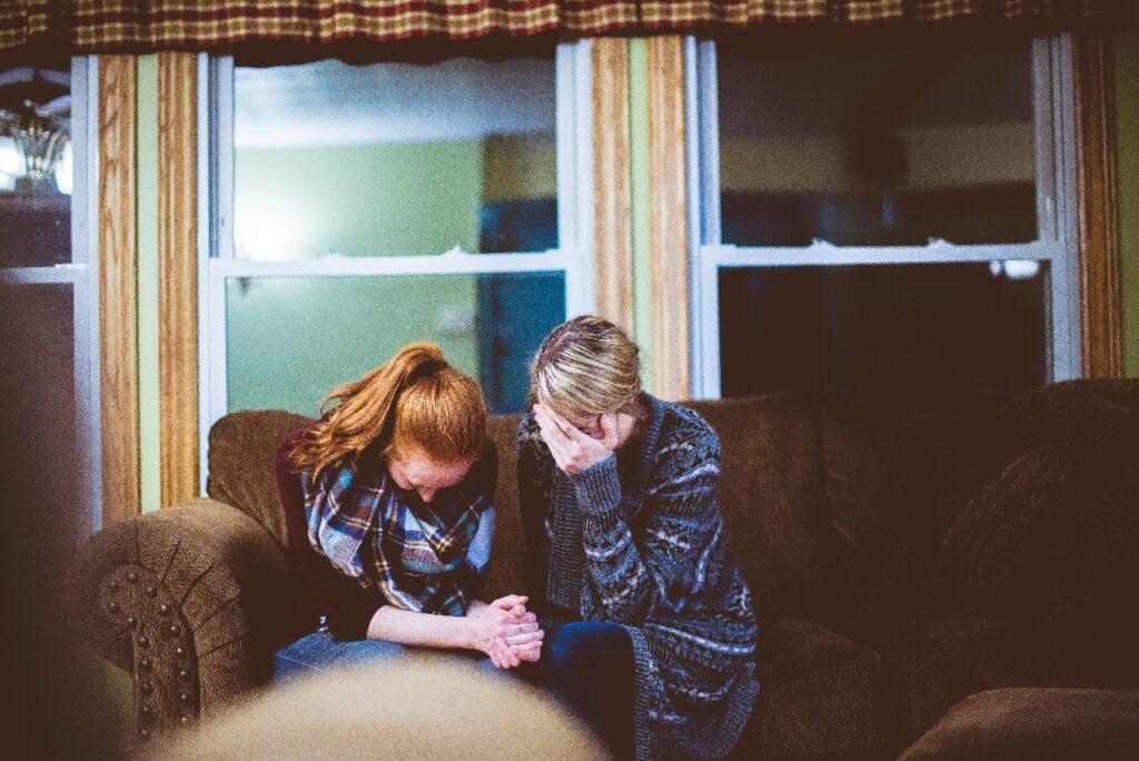 2 women praying white women in a living room