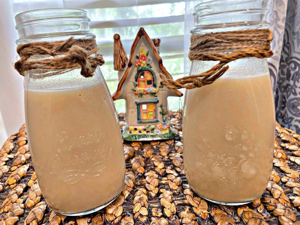 quinoa milk in 2 jars with a house in the background