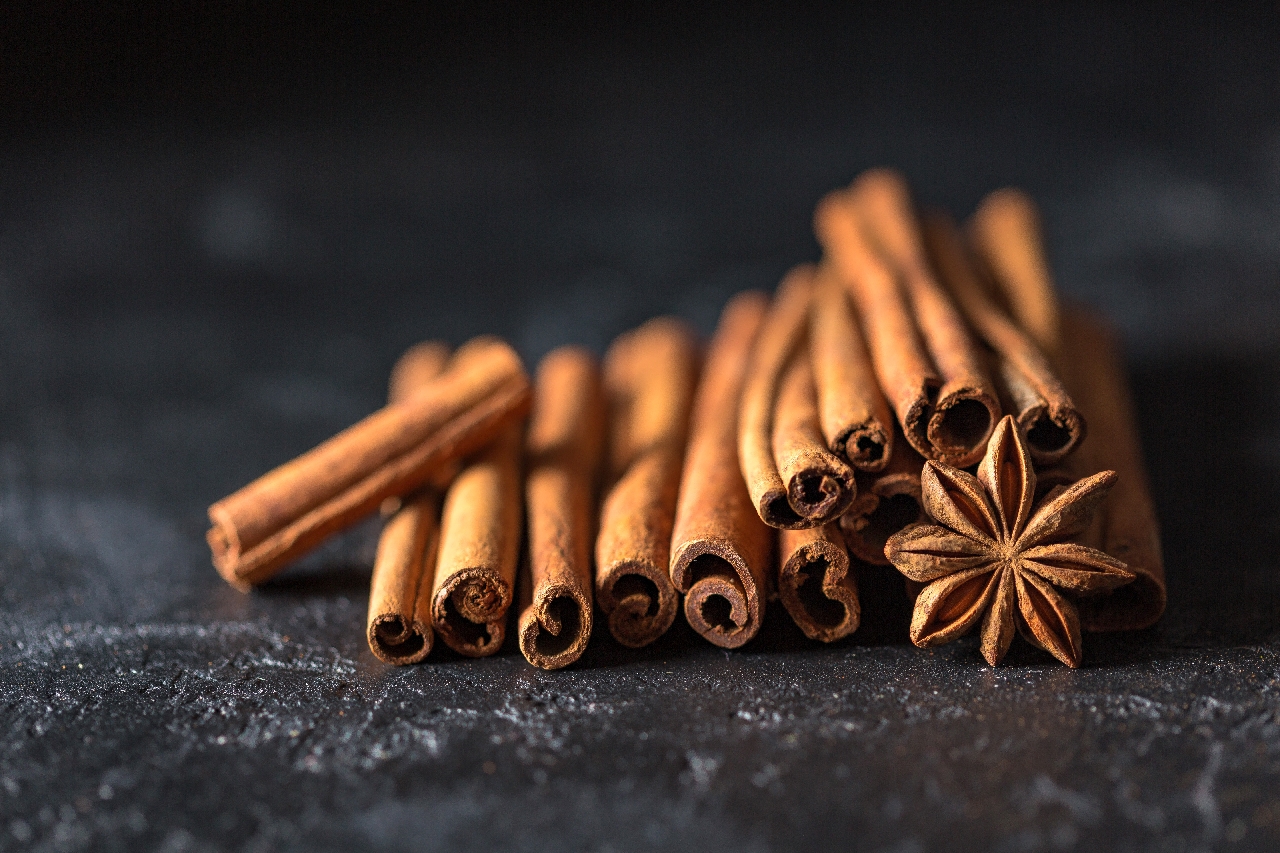 a stack of cinnamon sticks on a dark gray background