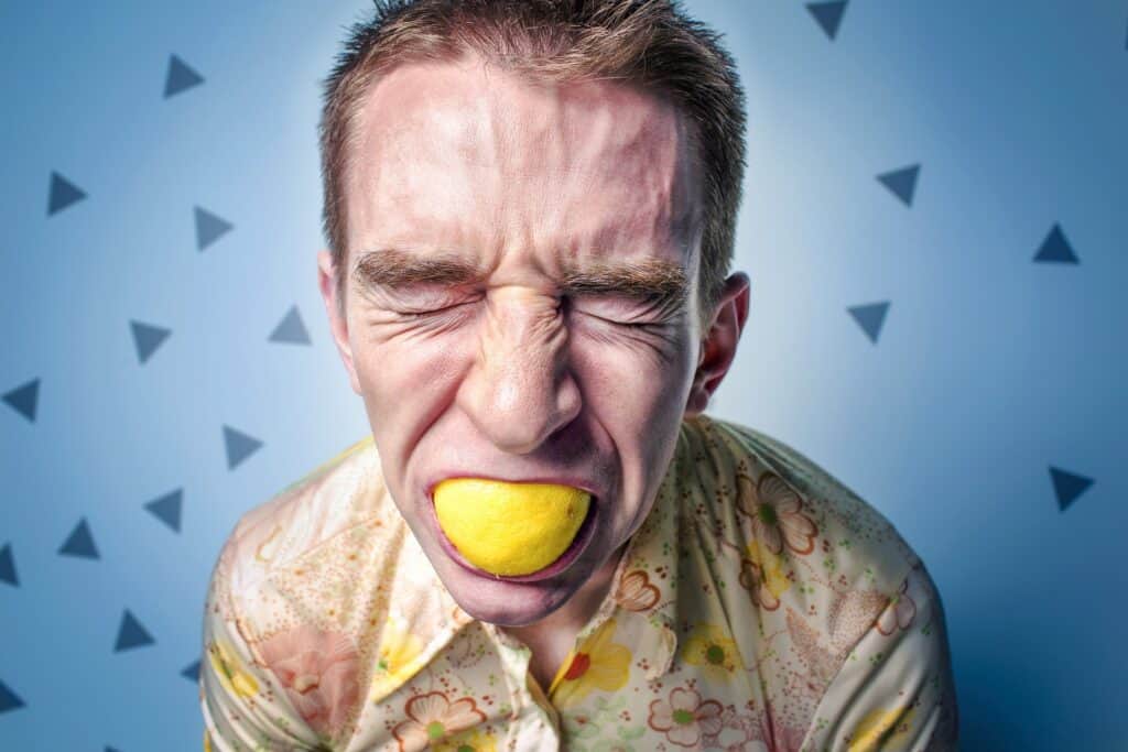 white man with lemon in the mouth, eyes closed, seemed stressed