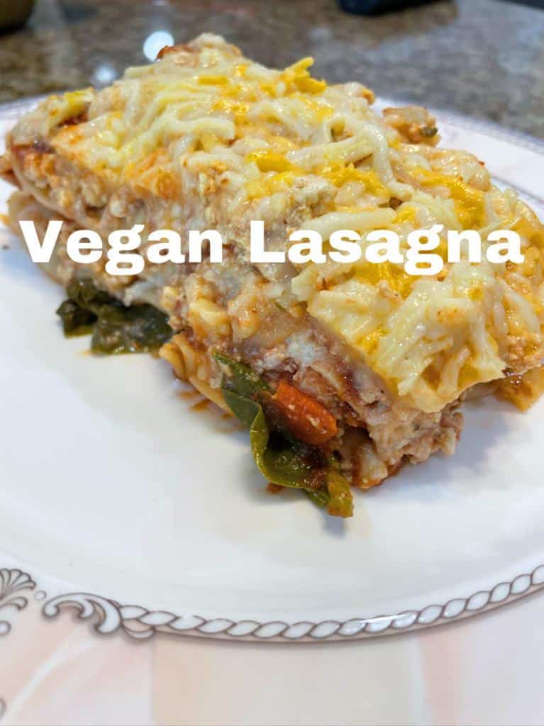lasagna on a white plate, vegan lasagna topped with vegan cheese