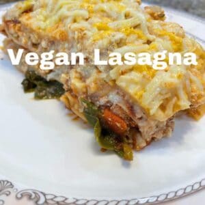 vegan lasagna with vegan cheese on top on a white plate