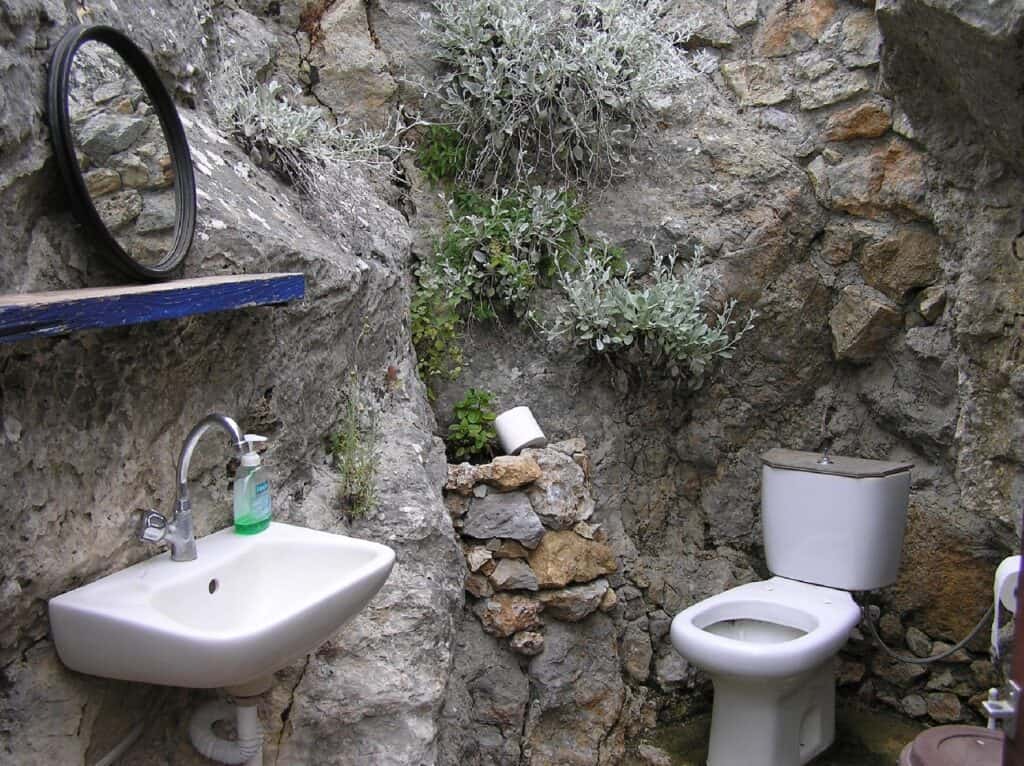 a bathroom in a rock environment, looks like it is outside