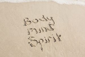 body mind spirit written on the sand