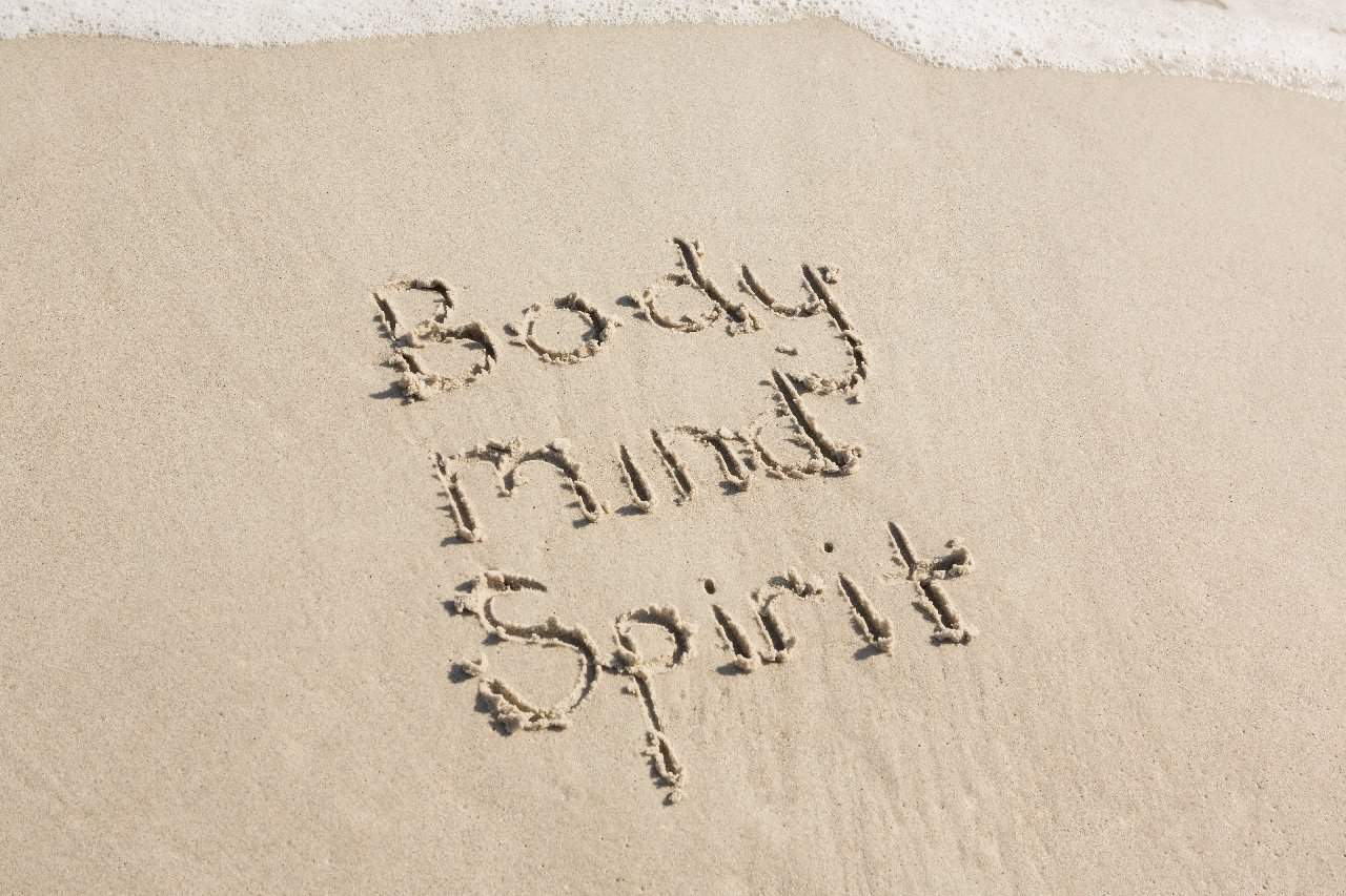 body mind spirit written on the sand 