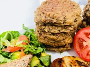burgers stacked with GREEN SALAD WITH TOMATO AND SLIDED POTATOS