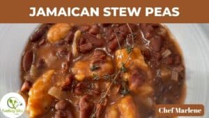 JAMAICAN STEW PEAS WITH BEANS AND DUMPLINGS PICTURED IN A WHITE PALTE WITH SPRIGS OF THYME ON TOP.